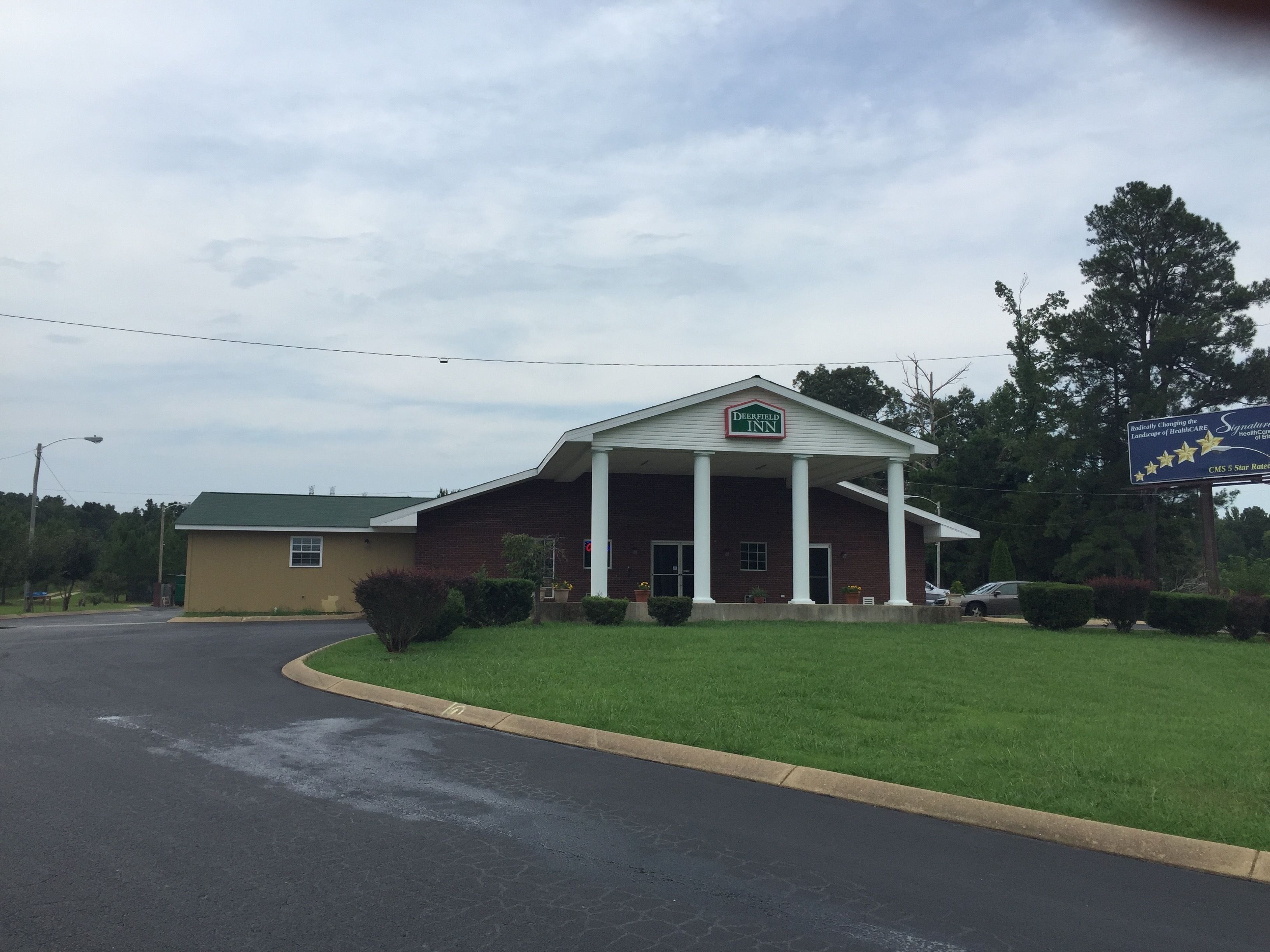 A Deerfield Inn with a brick facade, white columns, and a green lawn.