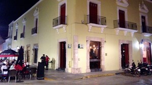 Un bâtiment jaune doté de balcons et d’une entrée au rez-de-chaussée.