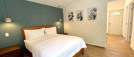 A bedroom with a wooden bed, a ceiling fan, and wall-mounted lights.