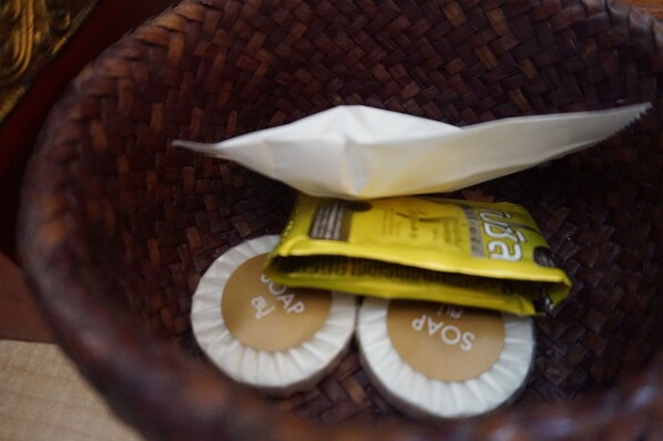 A woven basket containing soap bars and a folded paper airplane. - Thon Koon Resort (Surin)