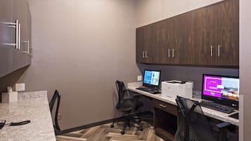A modern office space with two desks, two chairs, a computer, and a phone.