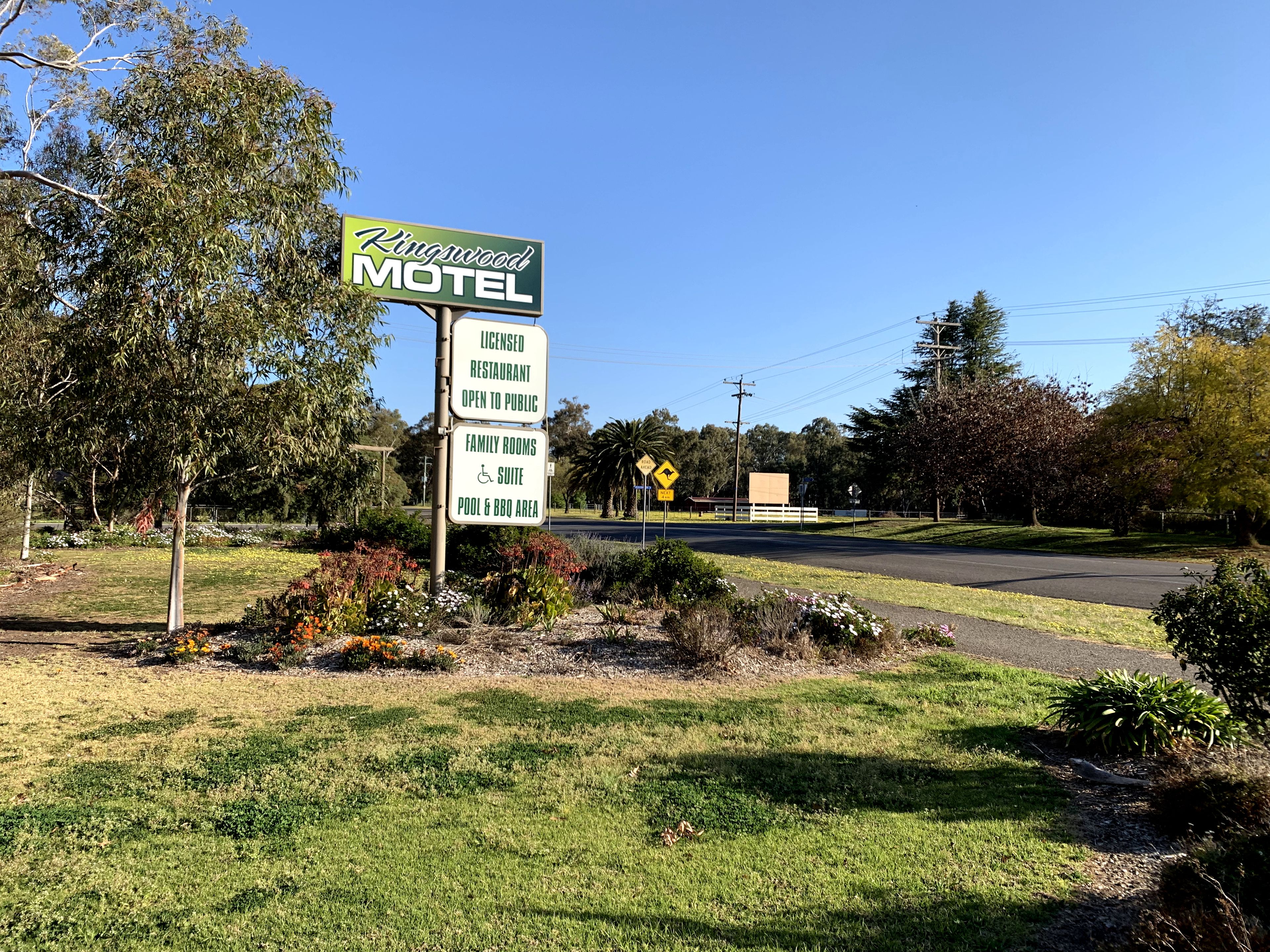 Motel Schild mit Annehmlichkeiten wie einem Restaurant mit Alkoholausschank, Familienzimmern, einer behindertengerechten Suite und einem Pool- und Grillbereich.