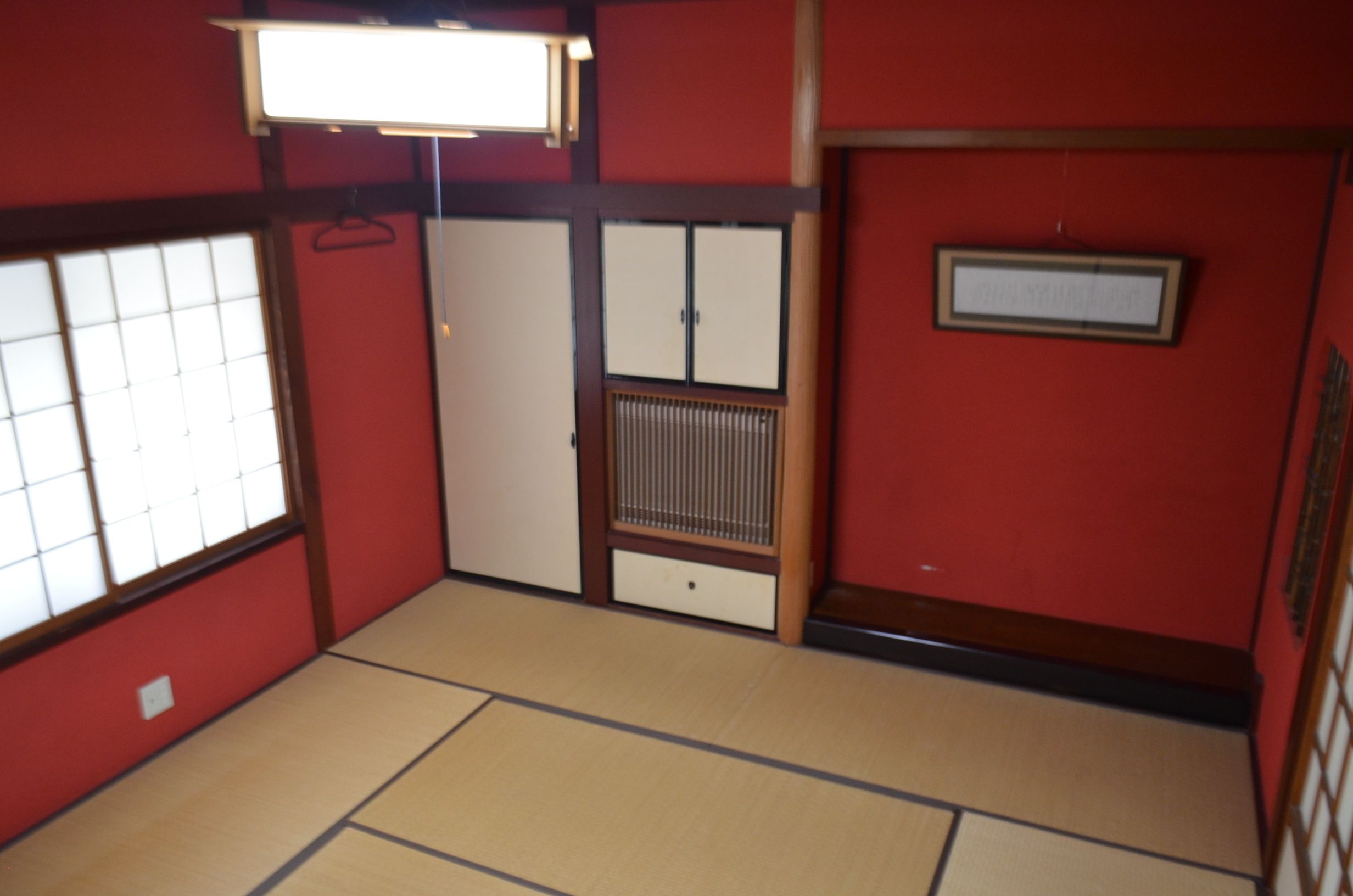 A traditional Japanese room with tatami flooring, sliding doors, and a shoji screen.
