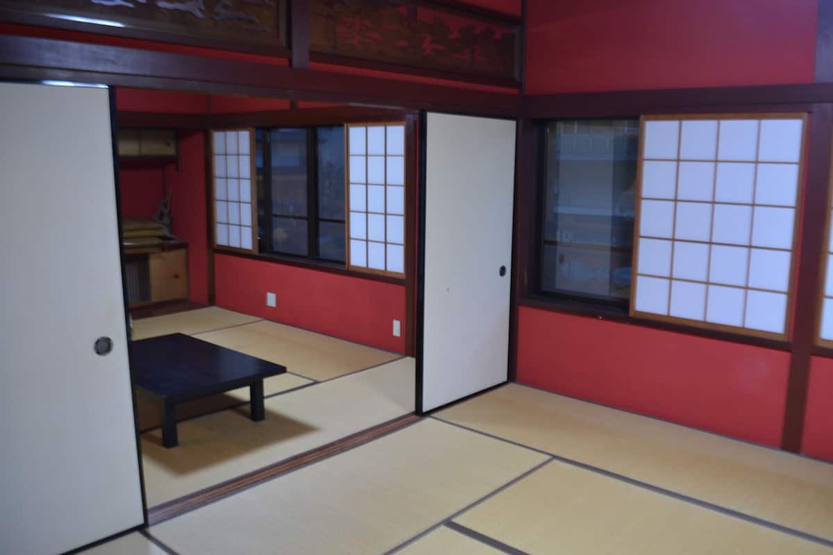 Ein traditioneller japanischer Raum mit Tatami-Boden, Schiebetüren im Shoji-Stil und einem niedrigen Holztisch.