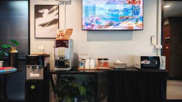 A coffee station with a coffee machine, cups, and a sign indicating coffee time at 06:00 AM.