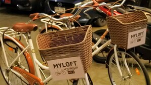 Ein Fahrrad mit Körbwannen und einem Schild mit der Aufschrift "MYLOFT".