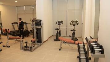 Una palestra con tapis roulant, ellittiche e panche per pesi.