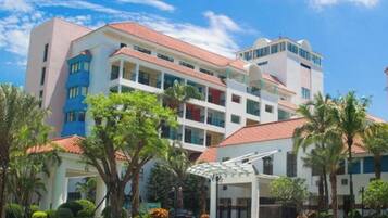 A multi-story hotel with a red-tiled roof, balconies, and a covered entrance area.