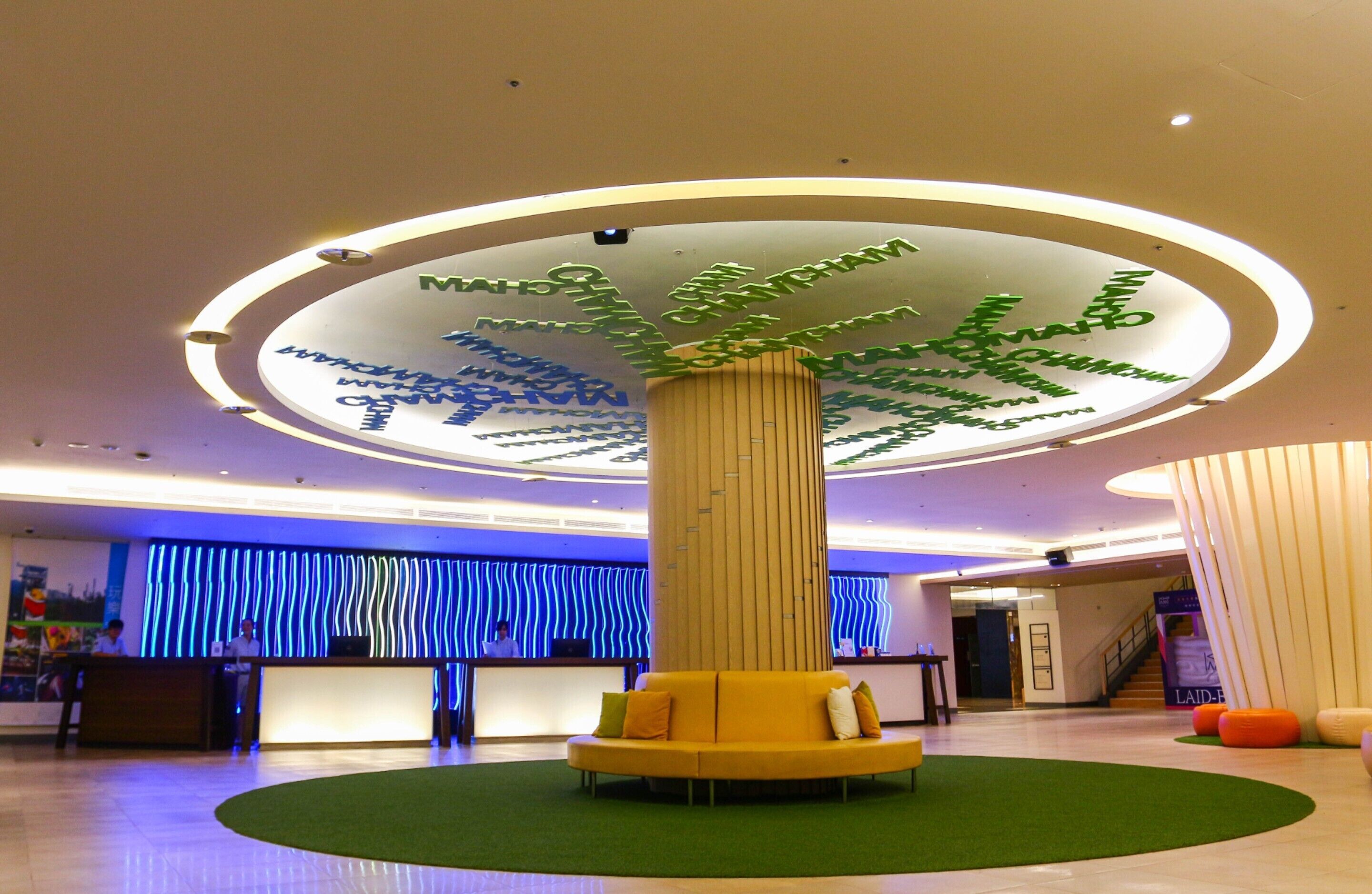 A lobby with a central column, reception desk, and a staircase.