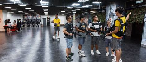 A group of people on hoverboards in a spacious indoor area with a polished floor and modern lighting.