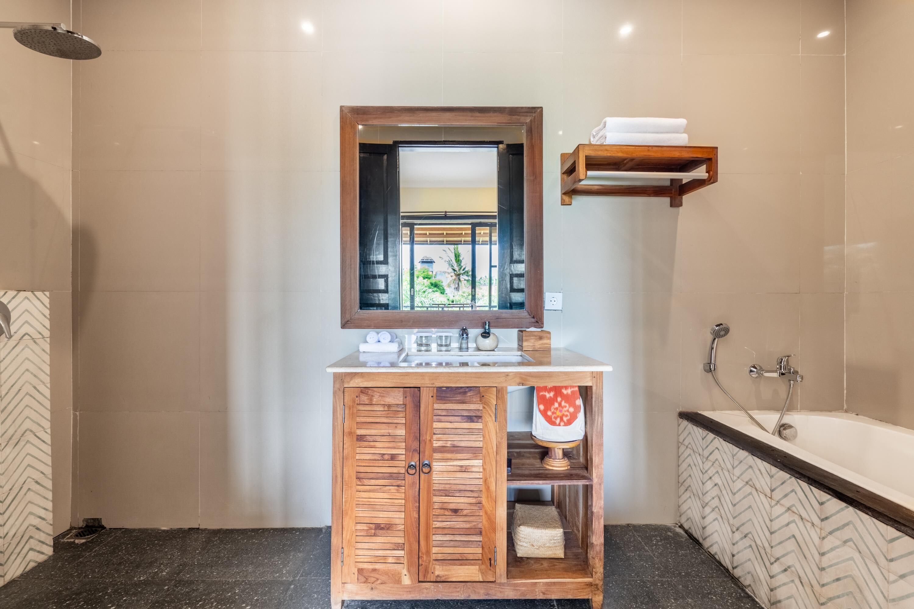 A modern bathroom with a wooden vanity, a large mirror, a bathtub, and a shower.