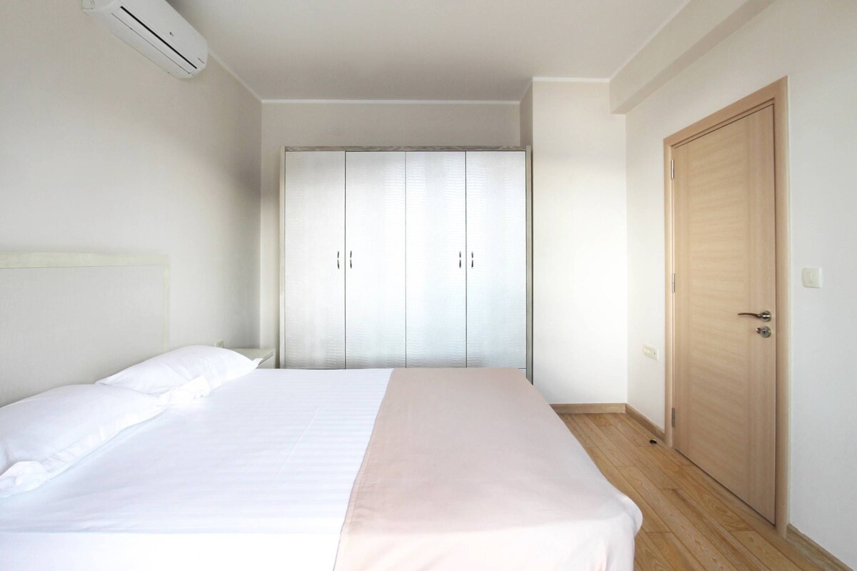 Une chambre à coucher avec un lit, une armoire et une porte.
