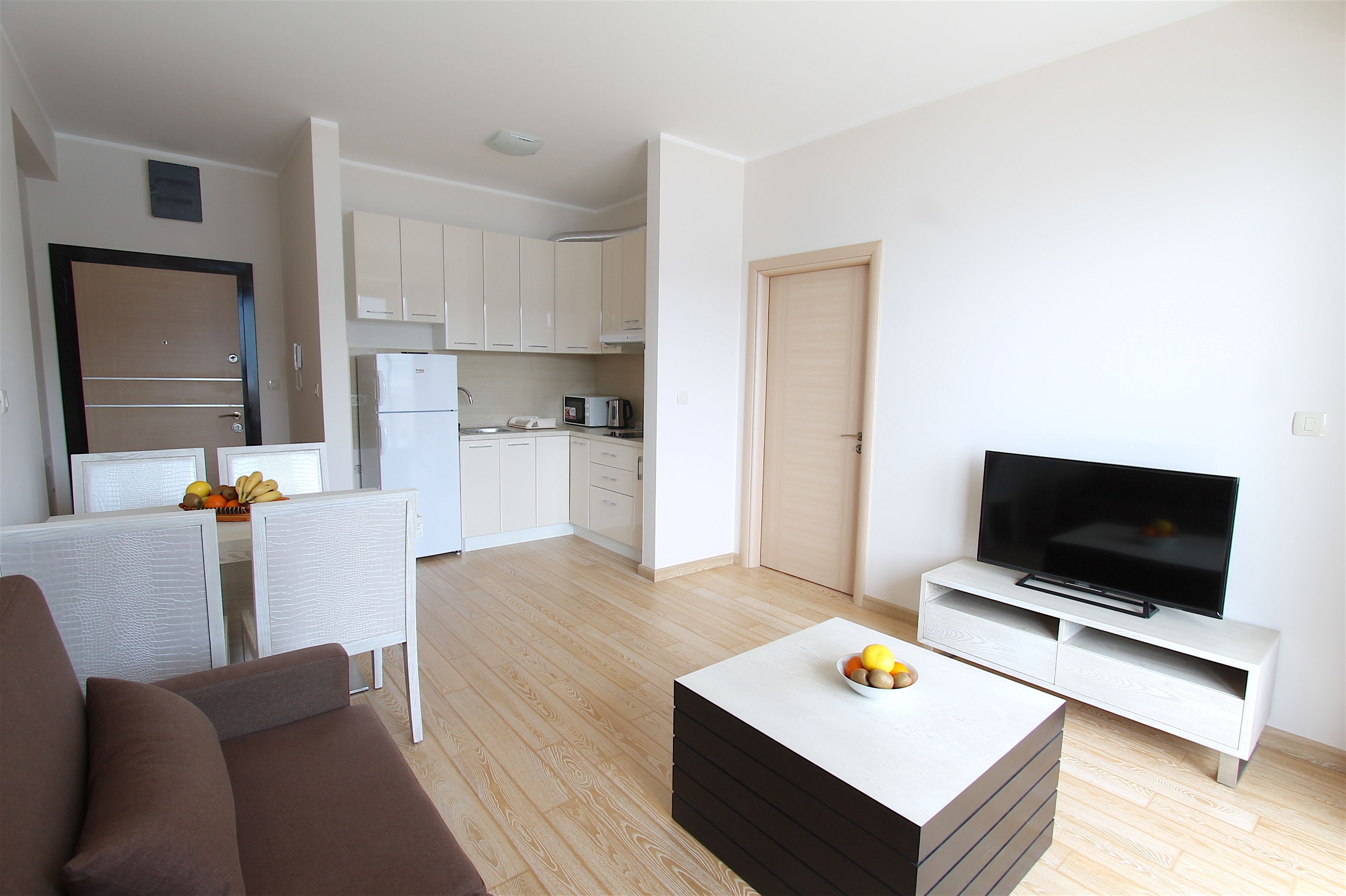 A modern apartment with a living room, dining area, and kitchen.