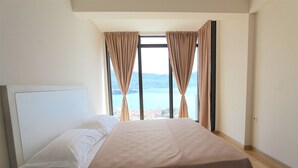 Une chambre d’hôtel avec un lit, une table de chevet et une fenêtre avec des rideaux.