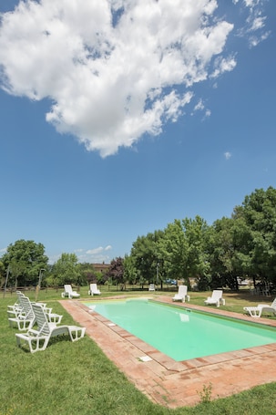Una piscina al aire libre, sillones reclinables de piscina