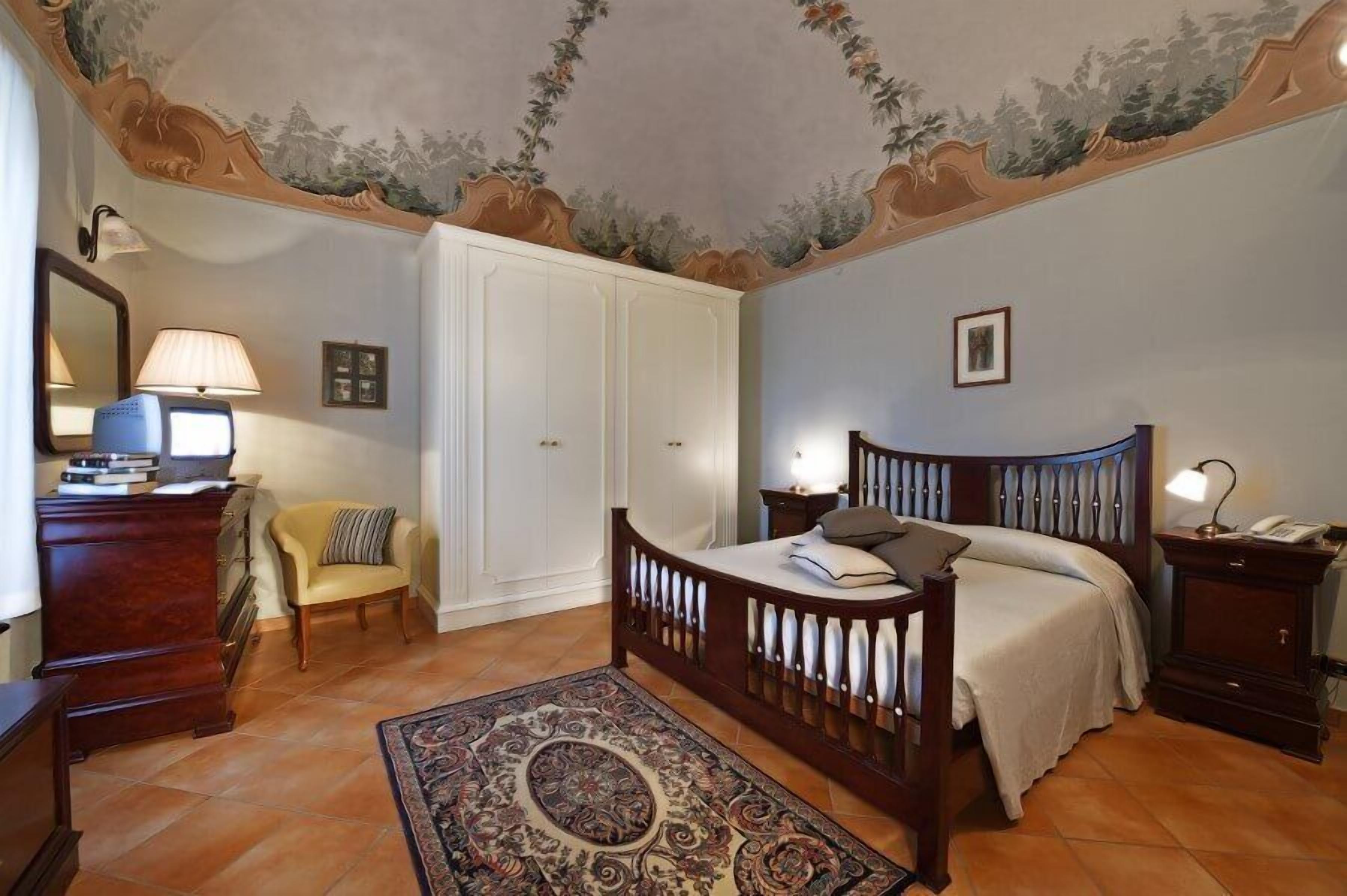 Ein Schlafzimmer mit Bett, Schreibtisch, Stuhl, Kleiderschrank und Teppich.