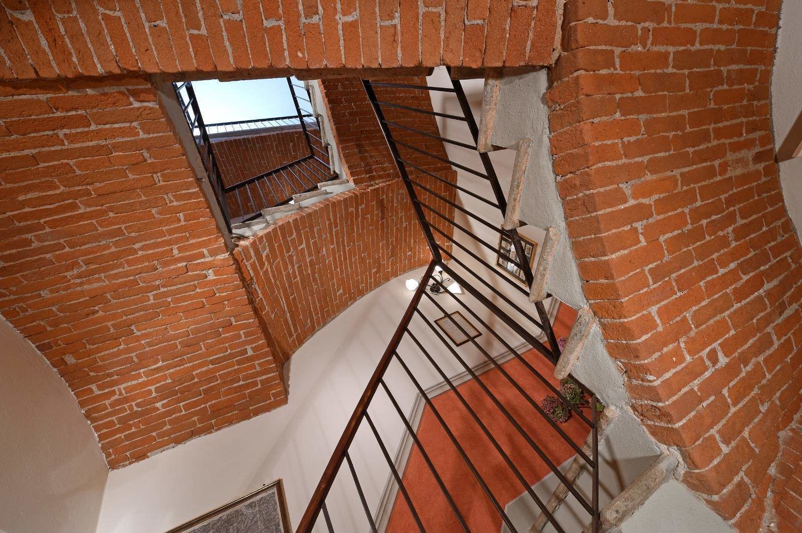 A brick staircase with a metal railing, leading to a lower level.