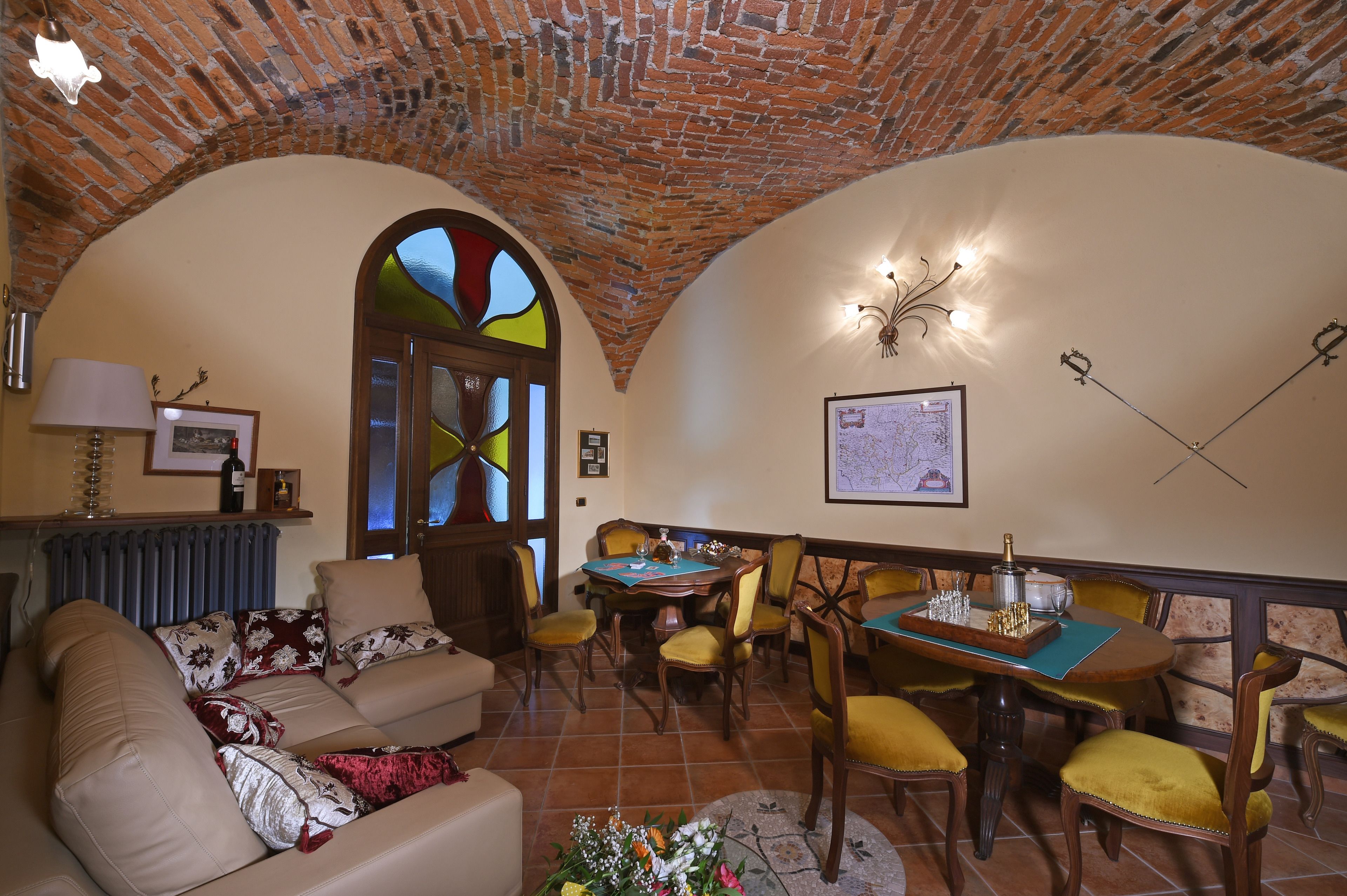 A cozy dining area with a brick ceiling, a stained glass window, and a map on the wall.