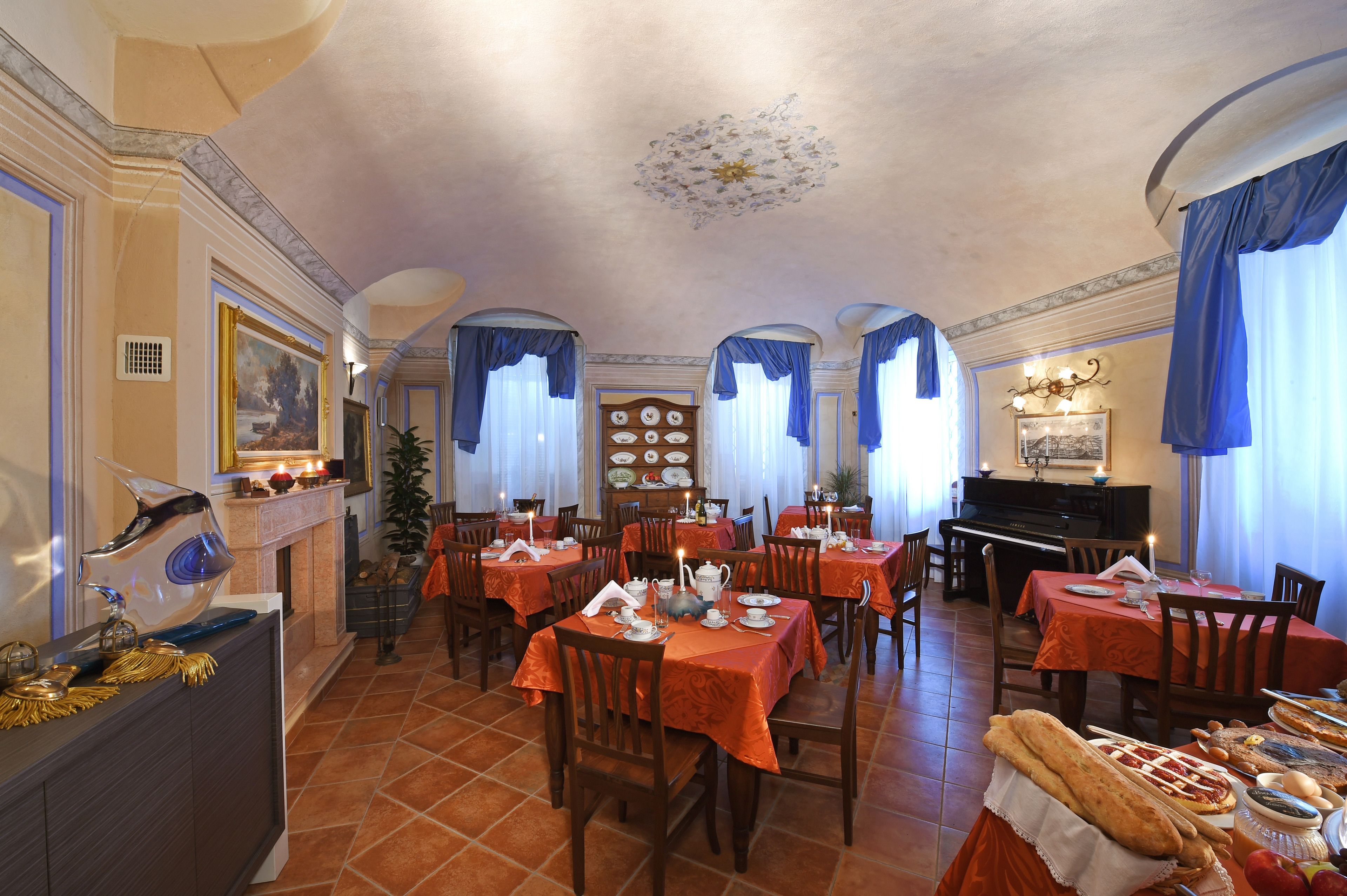 Un área de comedor con mesas dispuestas para comidas, un piano y una chimenea.