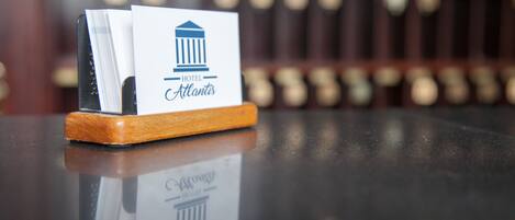 A hotel sign with a classical building icon and the name "Atlantic Hotel" on a wooden stand.