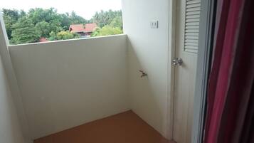 A small, enclosed balcony with a white door and a window.
