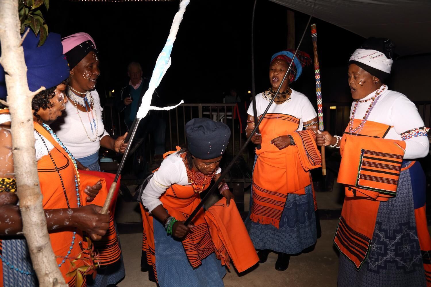 Un grupo de personas vestidas con atuendo tradicional bailando.