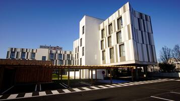 Ein modernes Gebäude mit Flachdach und überdachter Eingangszone.