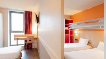 A hotel room with two beds, a desk, and a chair.