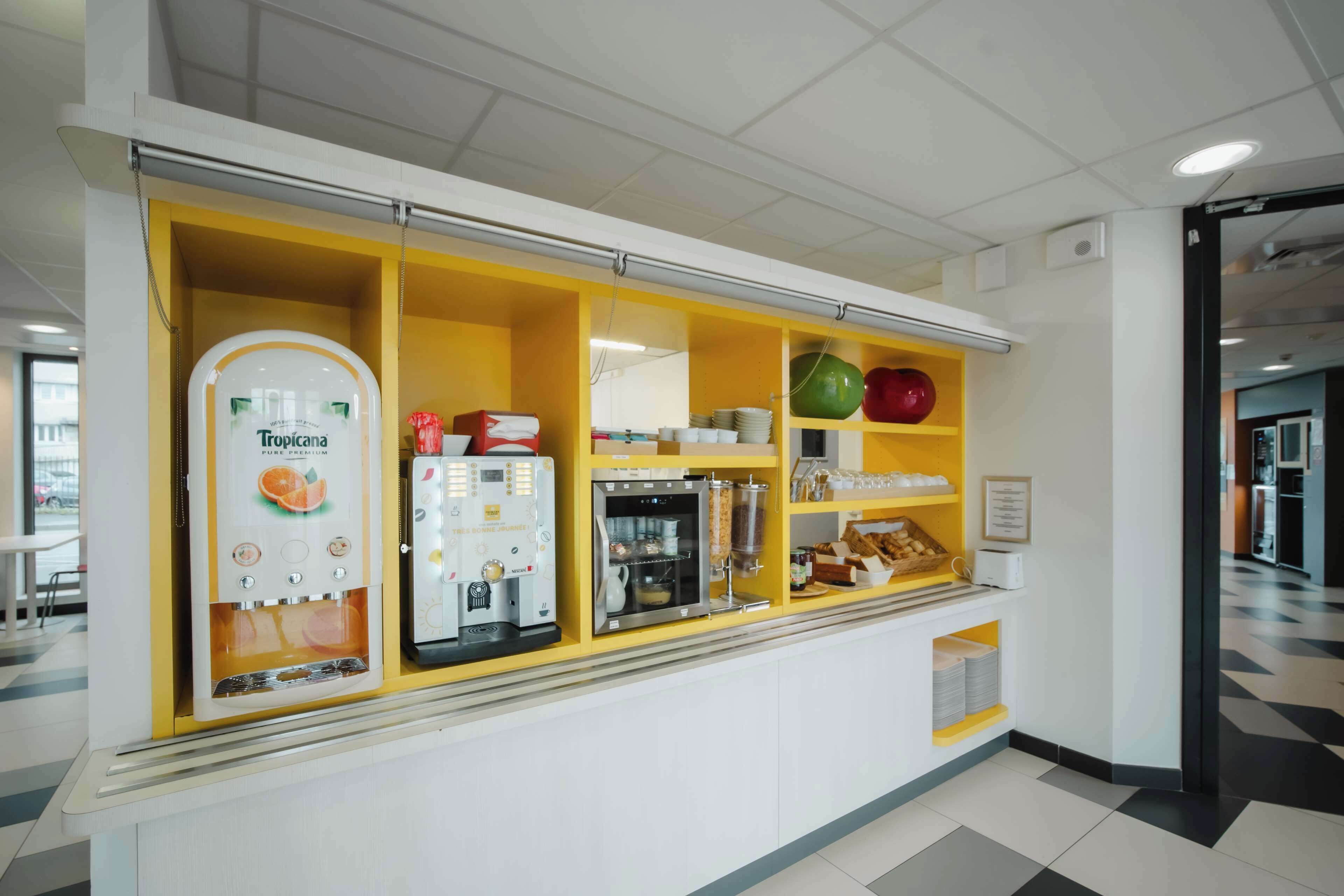 Eine Selbstbedienungsstation mit Kaffeeautomat, Saftspender und gekühlten Waren.