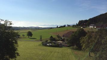 A rural landscape with rolling hills, a clear sky, and a few houses.