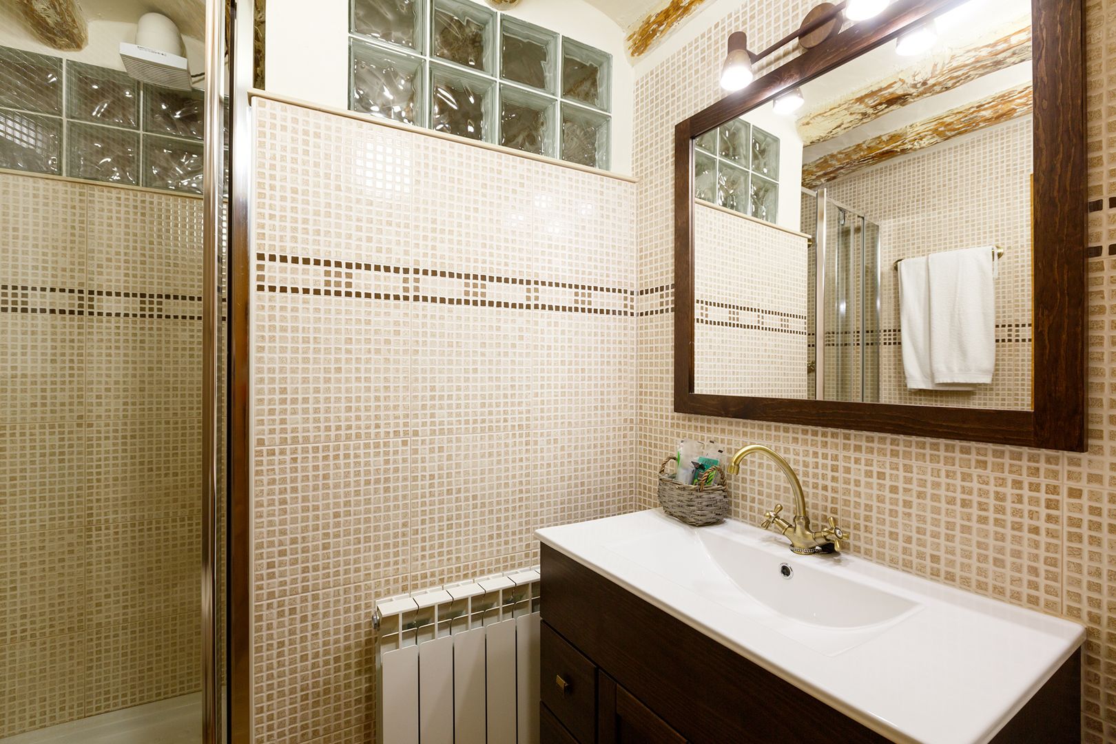 A bathroom with a white sink, a mirror, and a shower with glass doors.