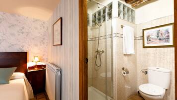Un baño con ducha de vidrio, inodoro y radiador.