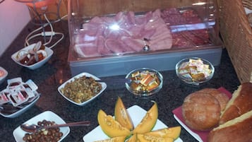 A buffet with various food items including meats, nuts, and bread.