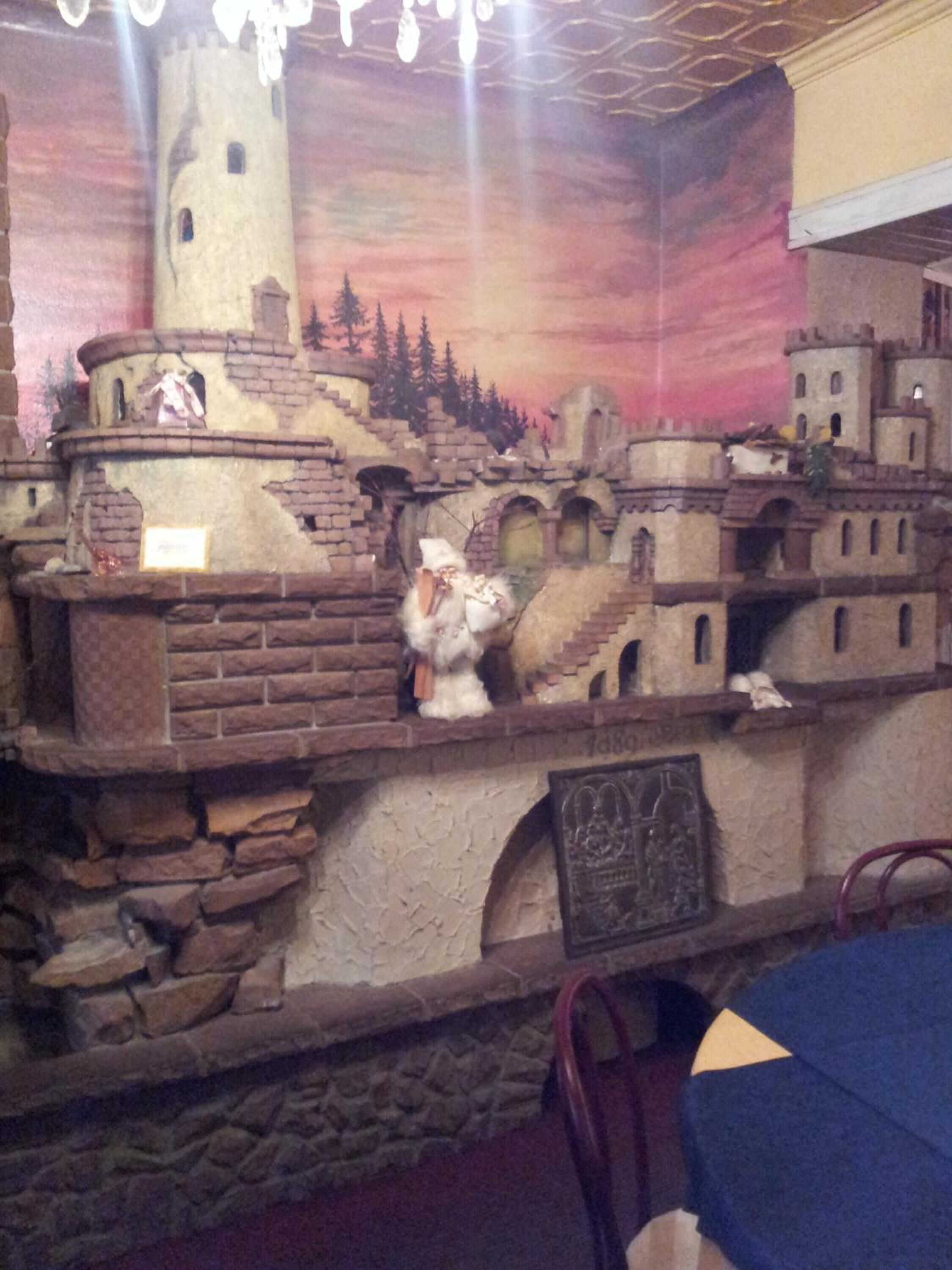 Un modelo de un pueblo medieval con edificios de piedra, una torre y una pequeña estatua de una figura.