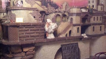 Un modelo de un pueblo medieval con edificios de piedra, una torre y una pequeña estatua de una figura.