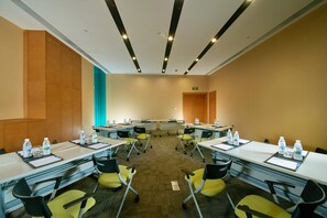 A conference room with multiple tables and chairs, equipped with water bottles and documents. - Holiday Inn Express Leshan City Square by IHG (Leshan)