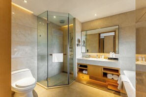 A modern bathroom with a glass-enclosed shower, a large mirror, and a vanity with a sink and towel storage.
