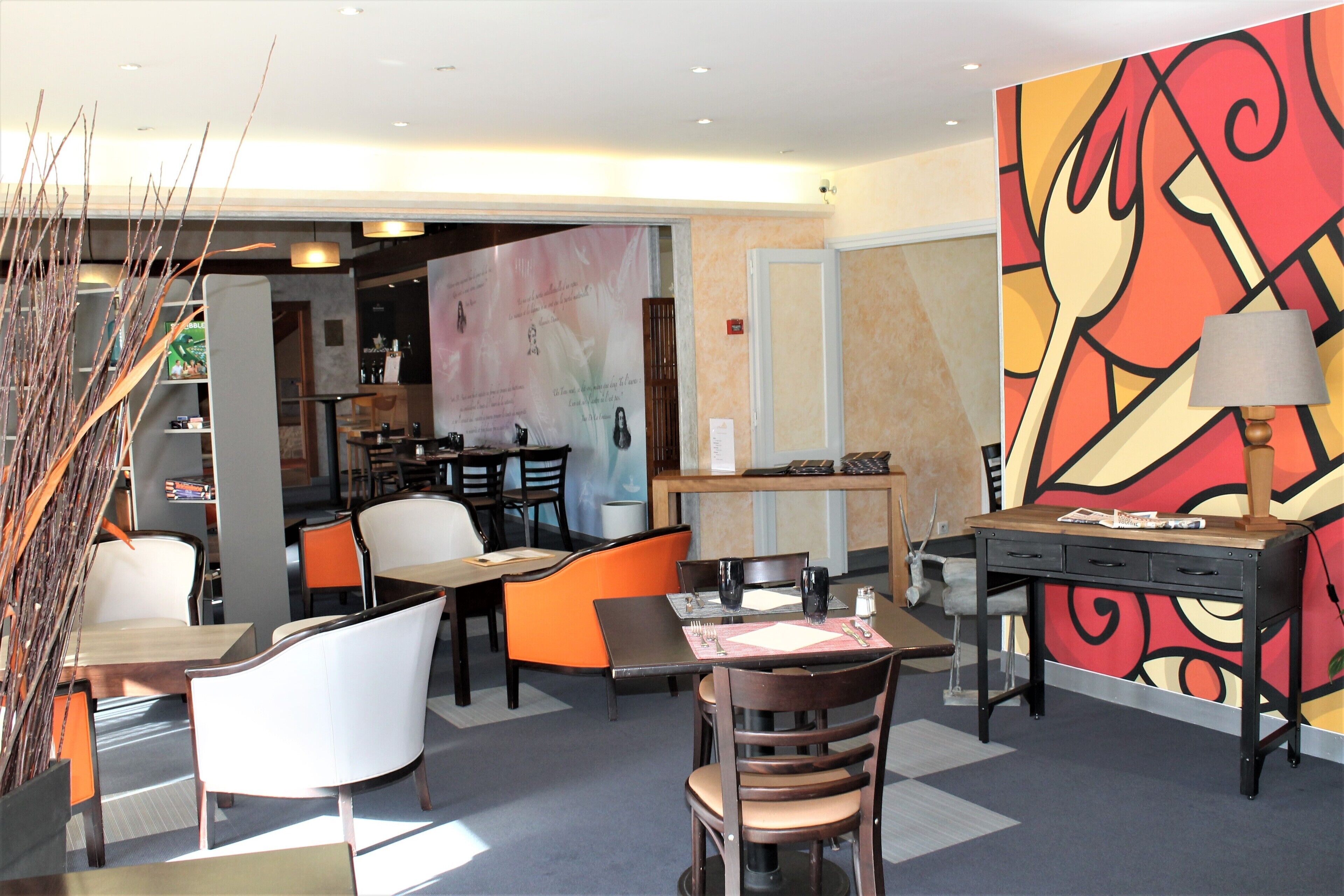 A modern dining area with a mix of seating options, including tables and chairs, and a vibrant abstract wall mural.