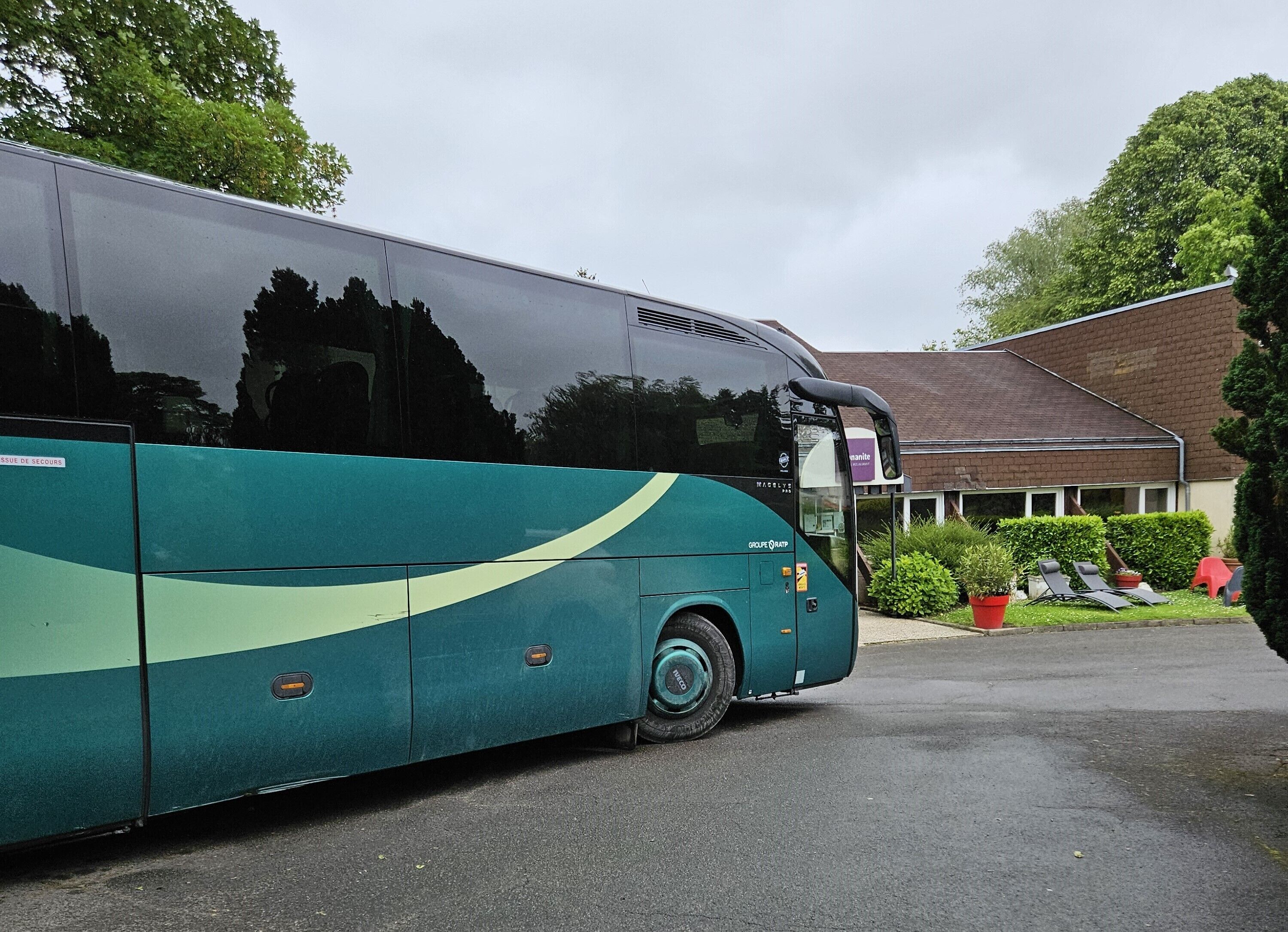 A large bus parked in front of a building with a sign that reads "Groupe VATP".
