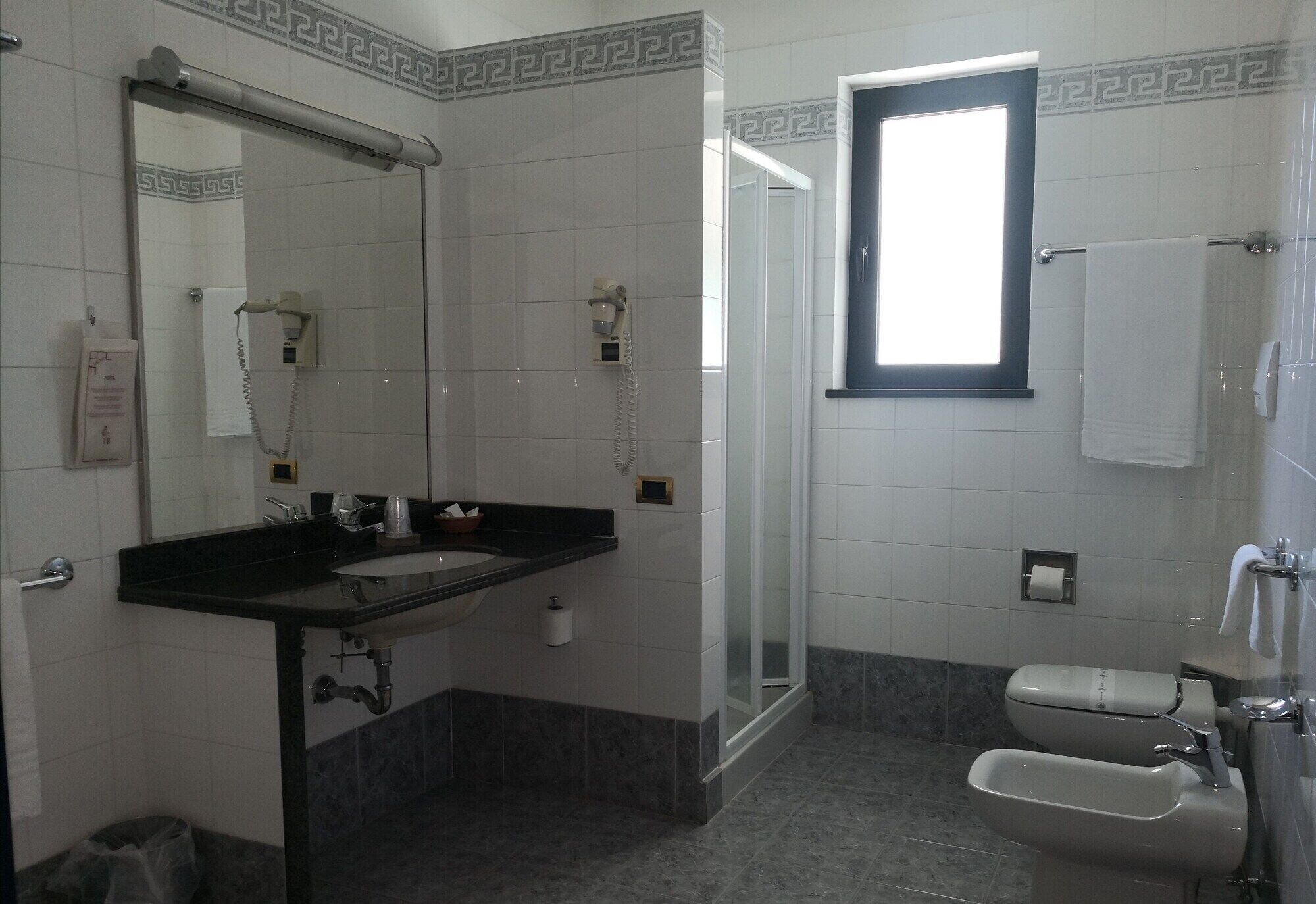 A bathroom with a sink, mirror, shower, and toilet.
