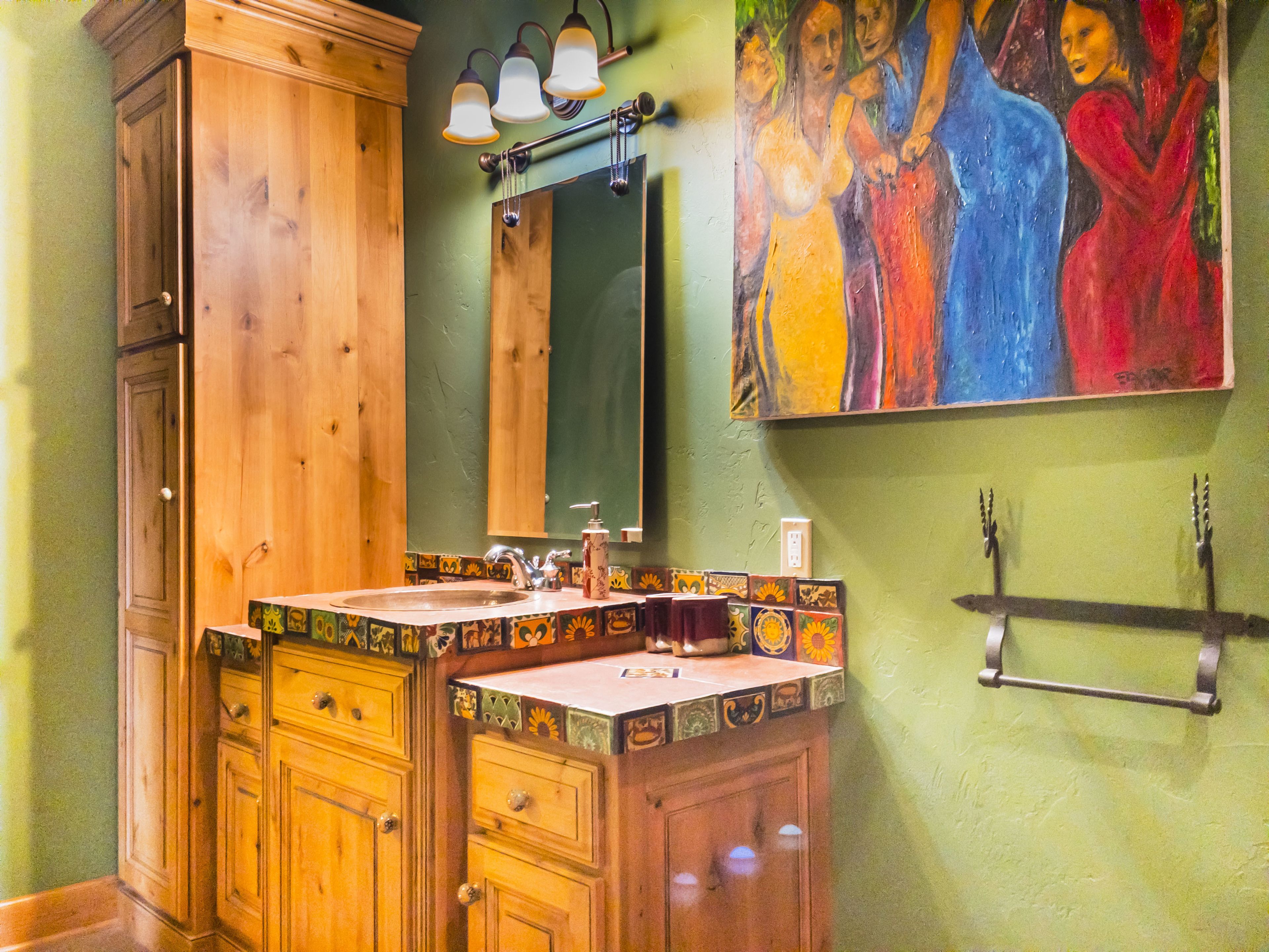 A bathroom with wooden cabinets, a sink with a decorative tile backsplash, a mirror, and a wall-mounted towel rack.