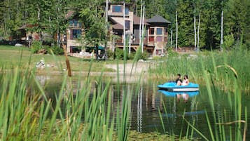 A house with a large deck and a pond.