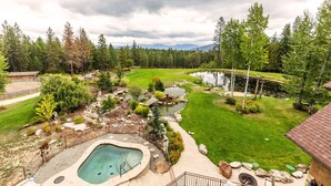 A residential property with a swimming pool, a small pond, and a well-maintained lawn. - Talus Rock Retreat (Sandpoint)
