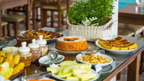 Una mesa de buffet con diversos alimentos, incluyendo un pastel y frutas en rodajas.