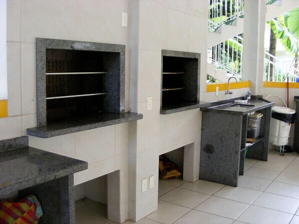 Una cocina con encimeras de granito, un fregadero y una ventana con vista a la vegetación.