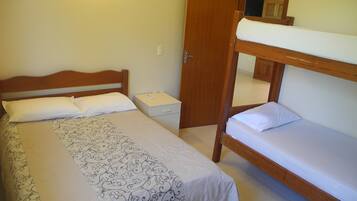 A bedroom with a single bed, a nightstand, and a wooden bunk bed.