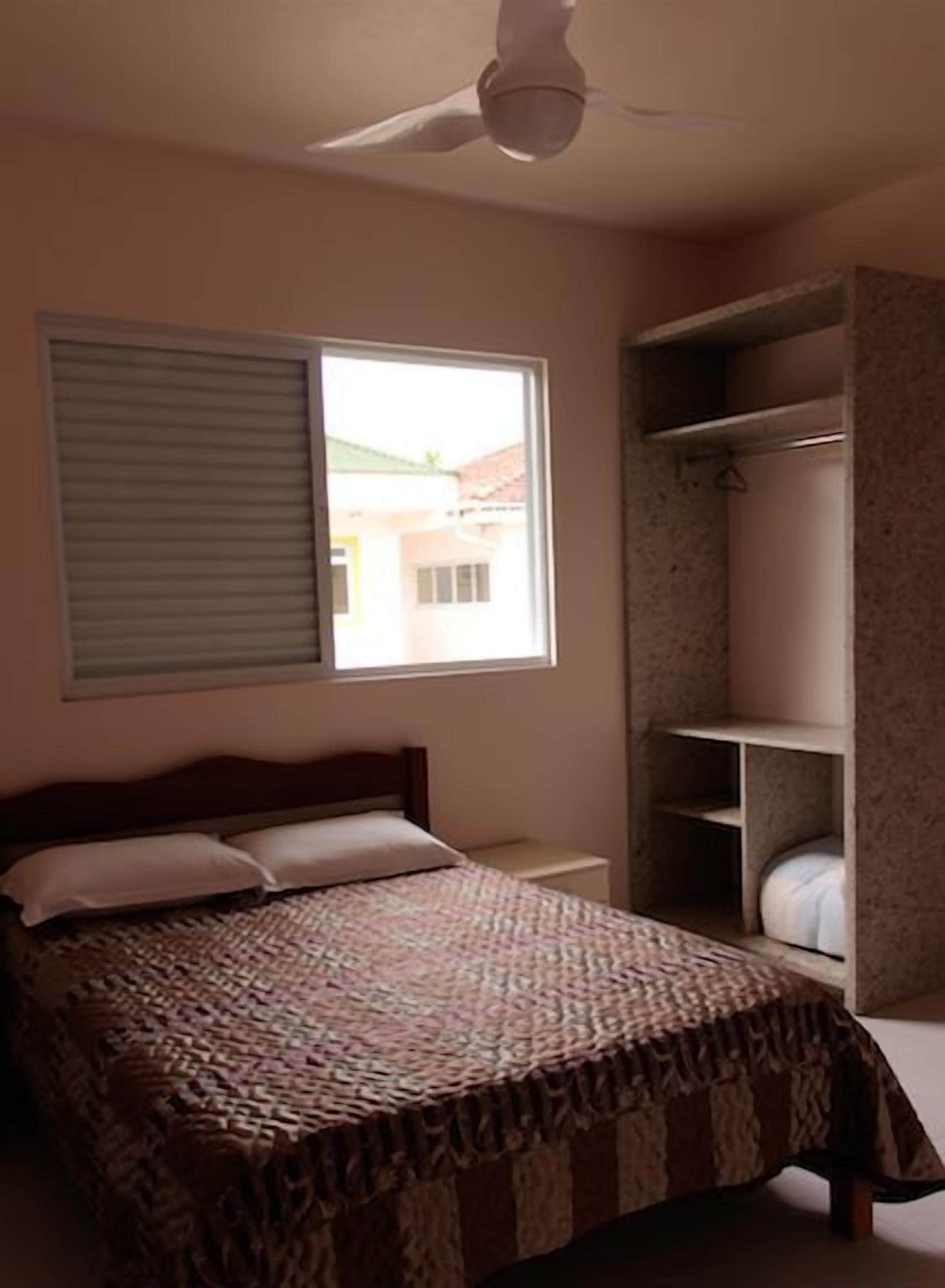 Un dormitorio con cama, ventana y armario.