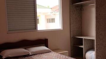 Un dormitorio con cama, ventana y armario.