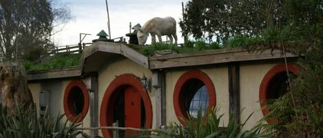 A building with red arched doors and a white animal statue on top.