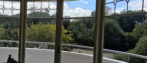 Una habitación con ventanas amplias que ofrecen vistas a un área boscosa.